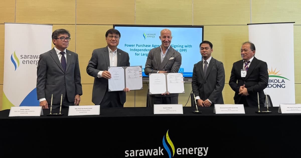 Five men stand behind a signing table at Sarawak Energy, two of them holding open the signed power purchase agreement, with Sarawak Energy and reNIKOLA Gedong banners on either side.